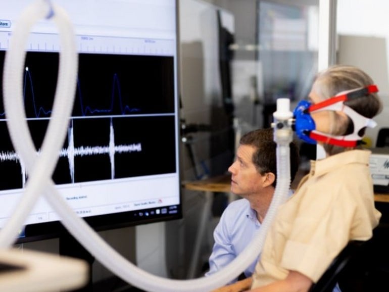 This shows the researcher and a woman on the breathing apparatus