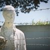 This shows a statue of a suffering man behind barbed wire