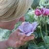 This shows a woman smelling a flower