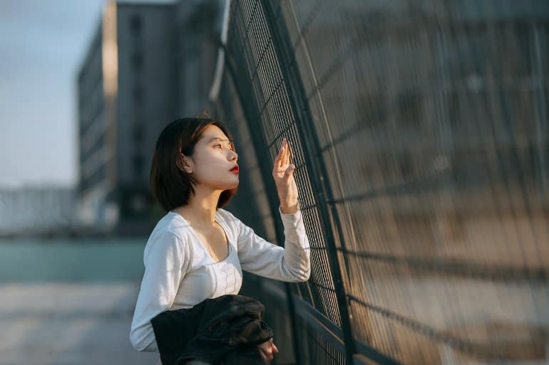 This shows a woman standing at a fence