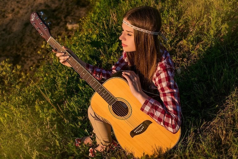 It shows a woman playing the guitar