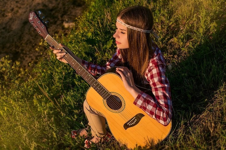 This shows a woman playing the guitar