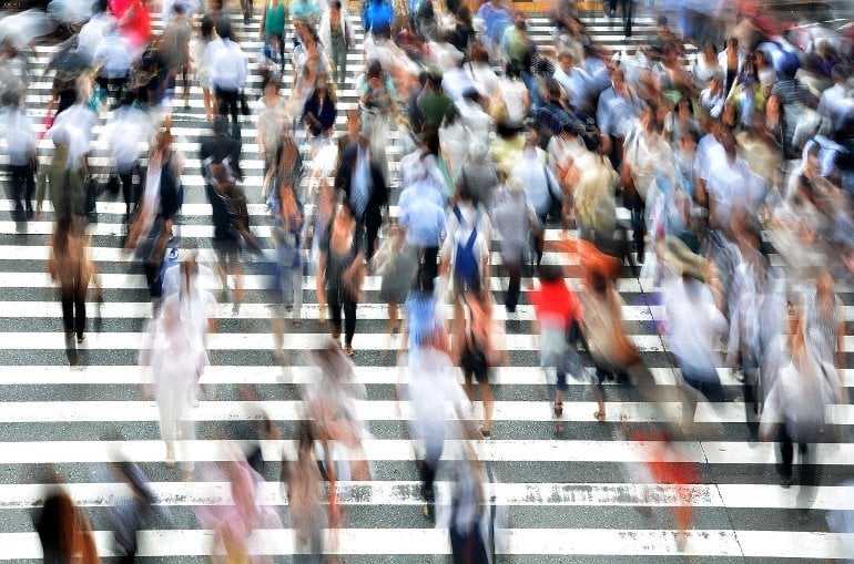 This shows a blur of people walking across a street