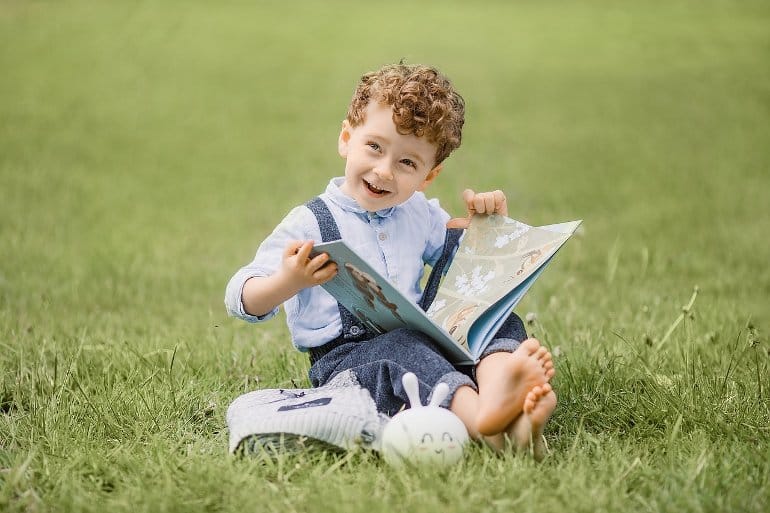 This shows a little boy reading a book