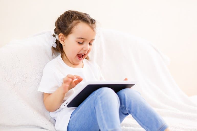 This shows a little girl using a tablet