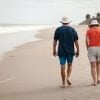 This shows a couple walking on a beach
