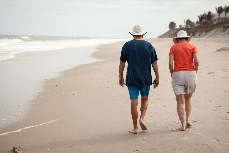 This shows a couple walking on a beach