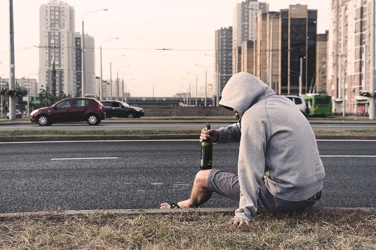 This shows a young person drinking at the side of a road