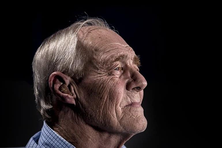 This shows an older man with a hearing aid