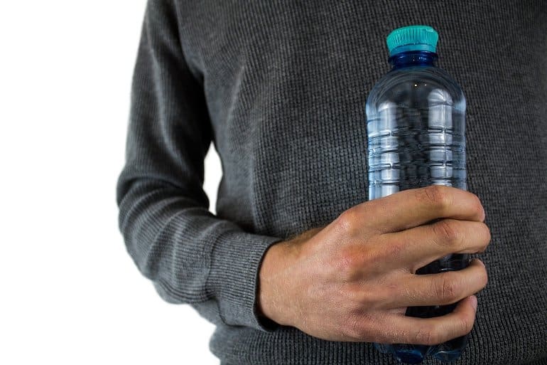This shows a man holding a plastic water bottle