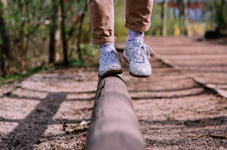 This shows a person walking along a thin log