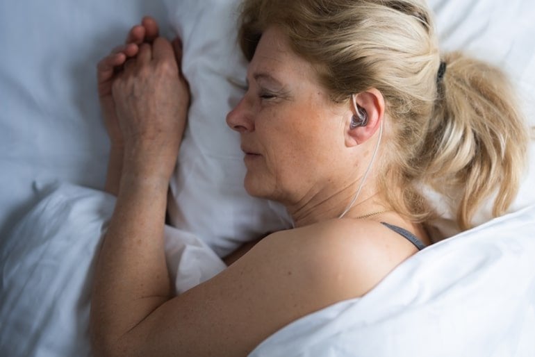 This shows a woman sleeping with the ear EEG in