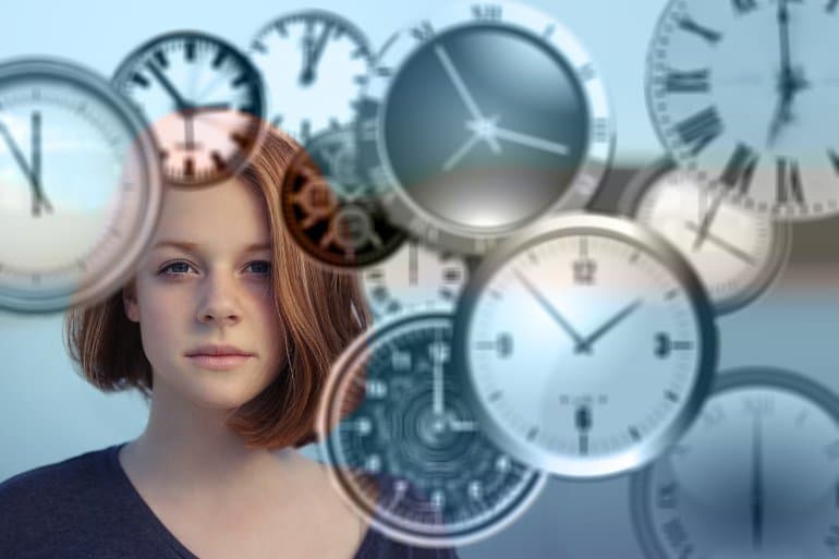 This shows a woman surrounded by clocks