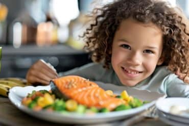 This shows a child eating salmon.