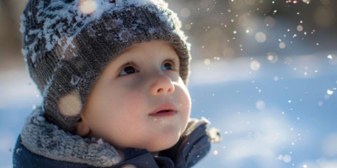 This shows a little boy playing in the snow.