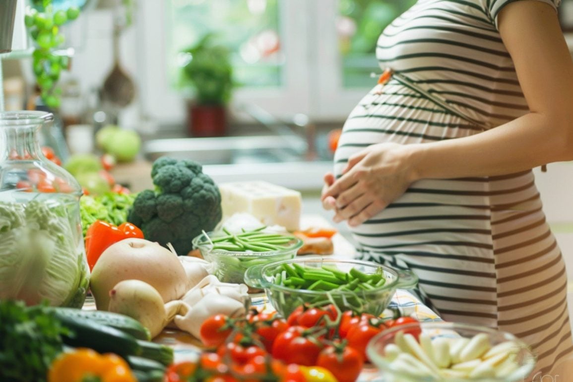 This shows a pregnant woman at a table with healthy foods.