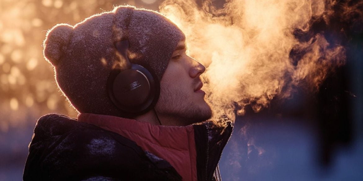 This shows a man wearing headphones on a cold day.