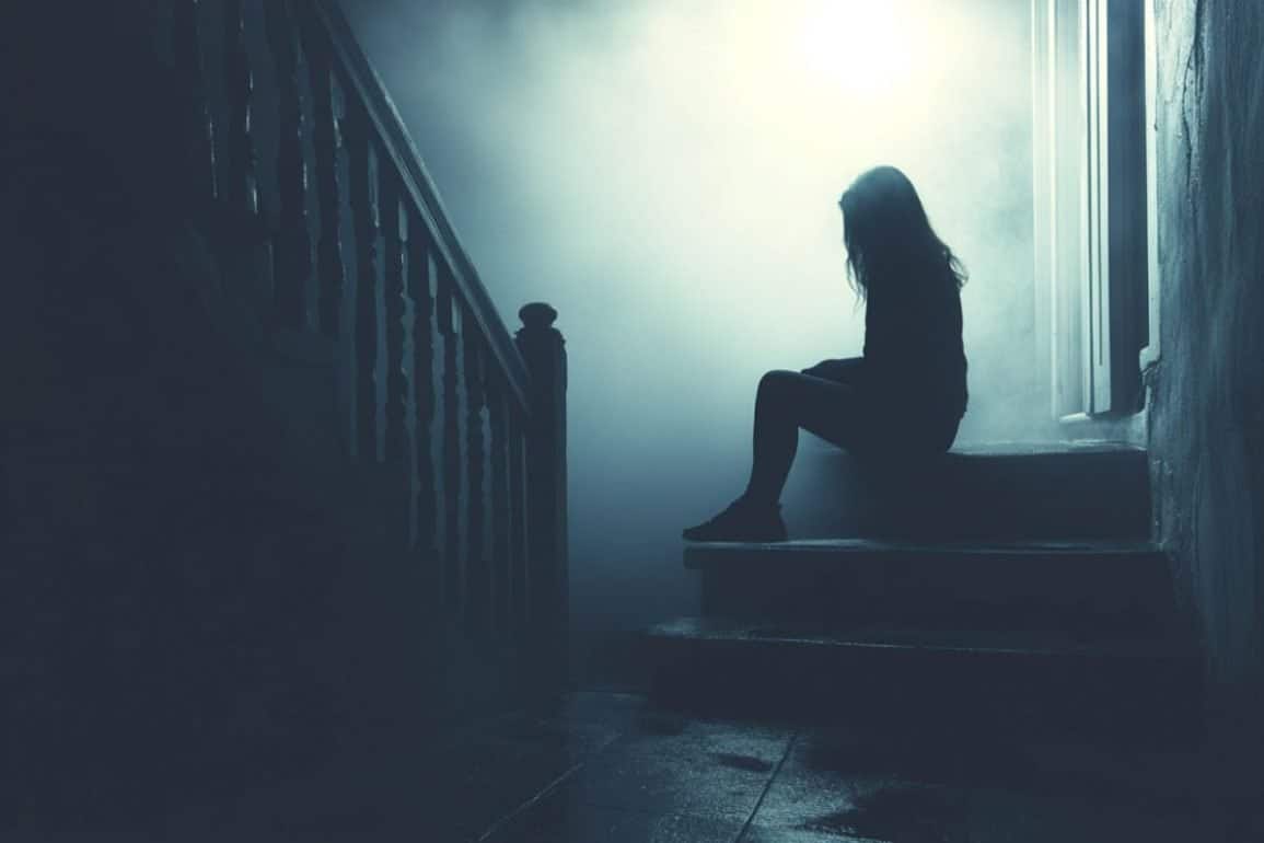 This shows a woman sitting alone on a step at night.