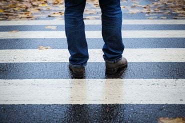 This shows a person standing still at a crosswalk.