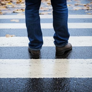 This shows a person standing still at a crosswalk.