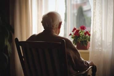 This shows an older man sitting alone.