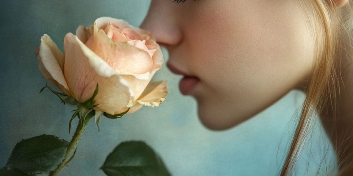 This shows a woman smelling a rose.