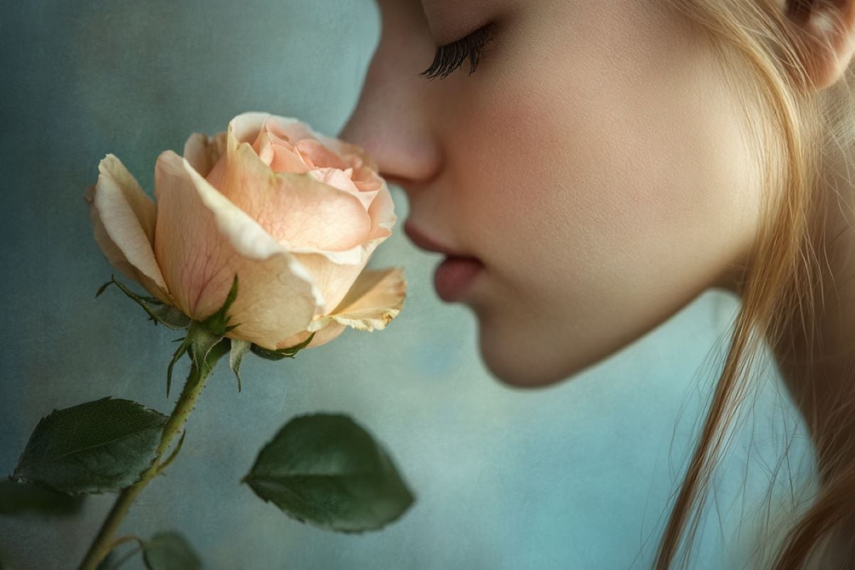 This shows a woman smelling a rose.