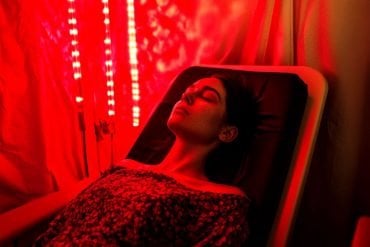 This shows a woman laying under a red light.