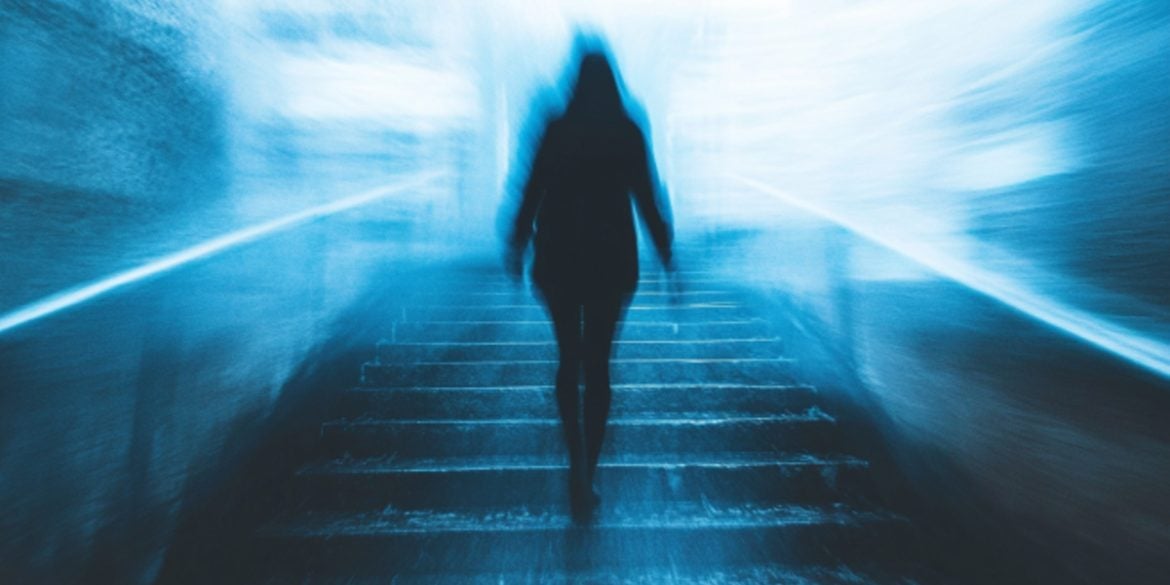 This shows a person walking in a dark hallway.