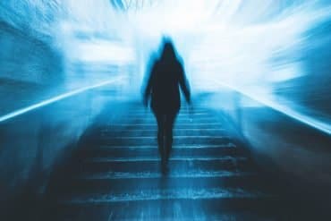 This shows a person walking in a dark hallway.