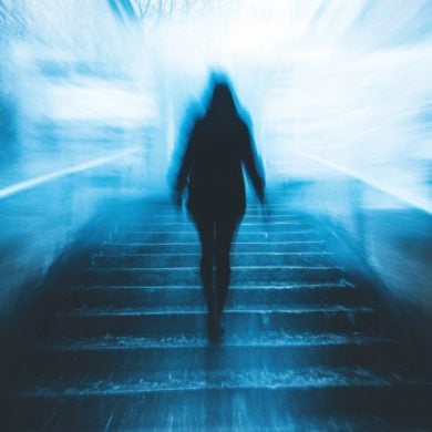 This shows a person walking in a dark hallway.