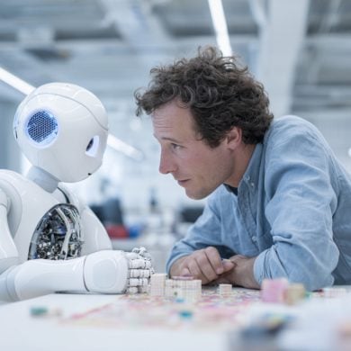 This shows a man making eye contact with a robot.