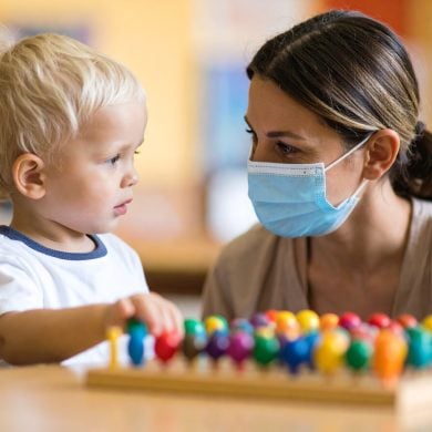 This shows a child and an adult in a surgical mask.
