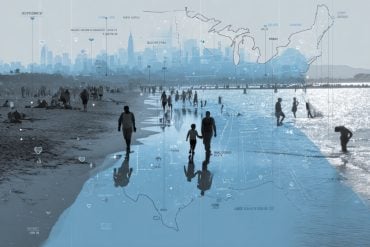 This shows people walking along a beach in the summer.
