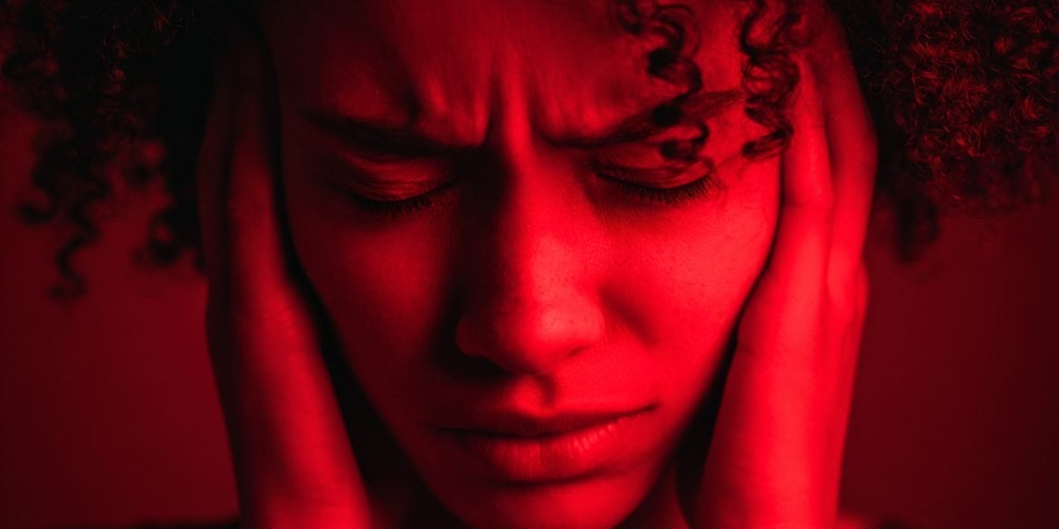 This shows a woman holding her head in pain.