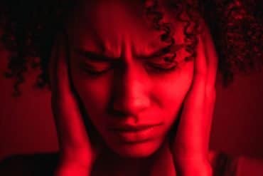 This shows a woman holding her head in pain.