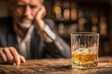 This shows a man and a glass of whiskey.