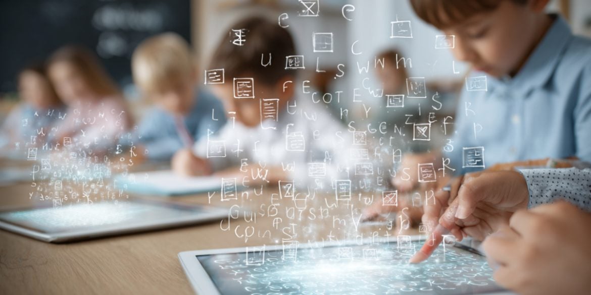 This shows a child working on a tablet in a classroom.