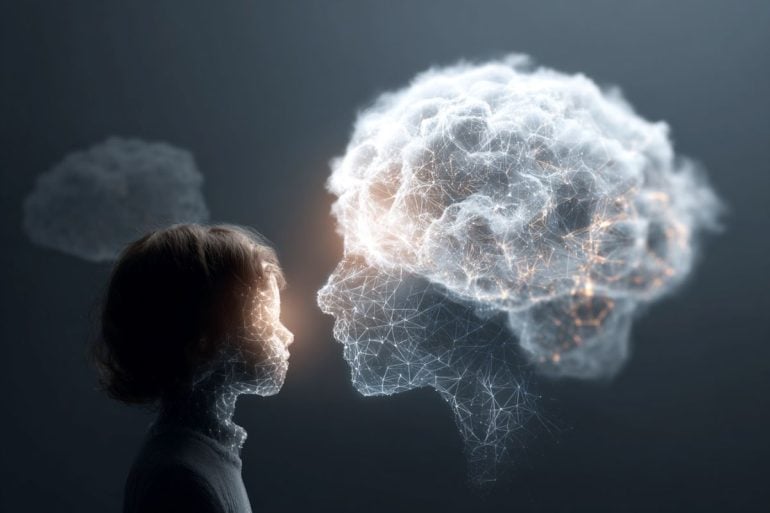This shows a person looking at a cloud covered, digital head, symbolizing a human connection with AI chatbots.