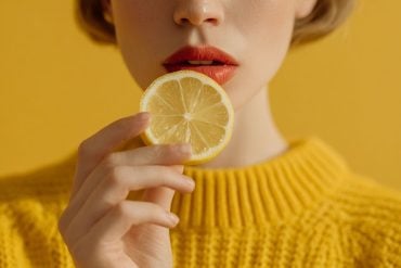 This shows a woman about to eat a slice of lemon.