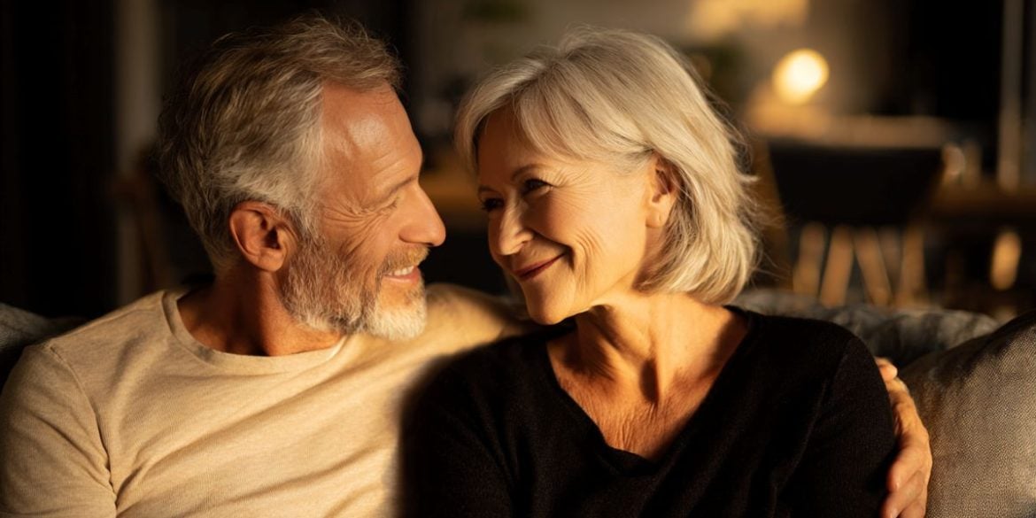 This shows an older couple hugging on a sofa.