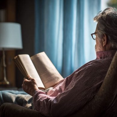 This shows an older person reading a book.