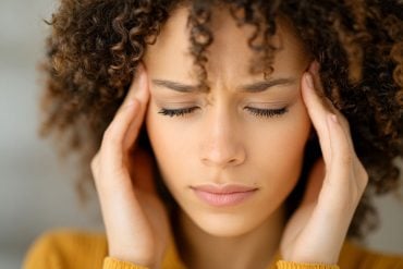 This shows a woman holding her head in pain.