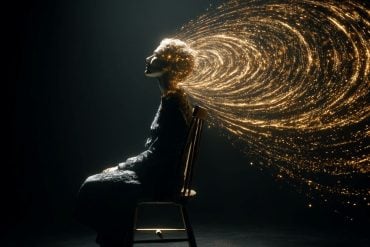 This shows a person in a dark room and golden sound waves.