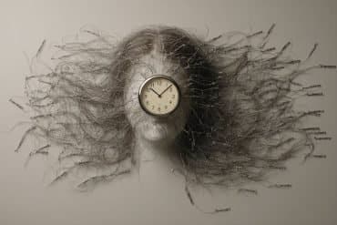 This shows a woman with her hair flowing and a clock.