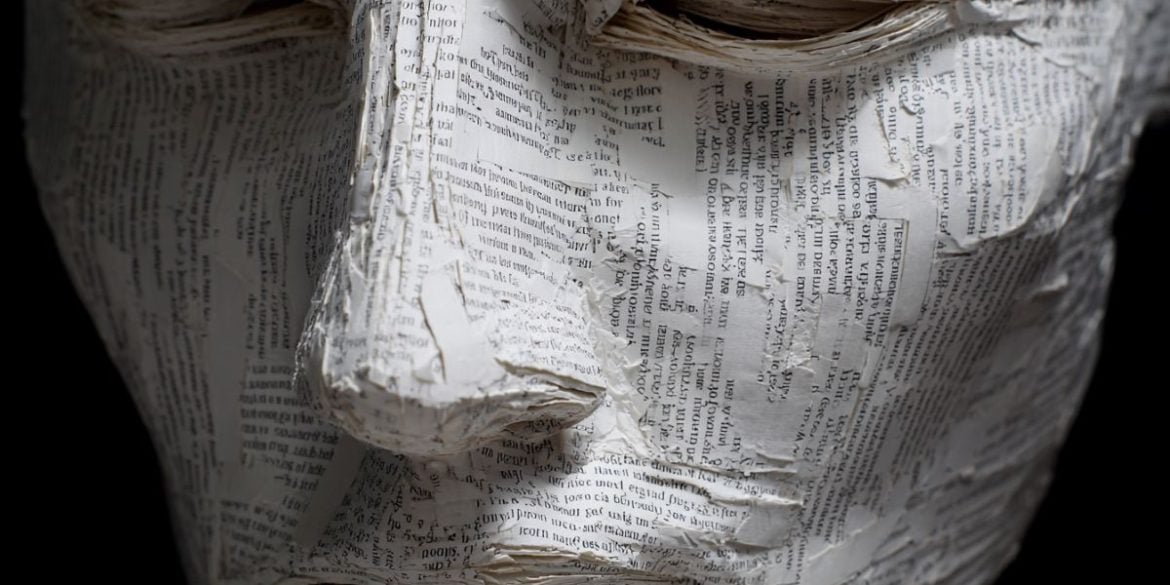 This shows a mask made of paper covered in words.