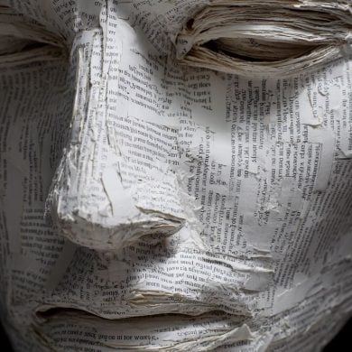 This shows a mask made of paper covered in words.