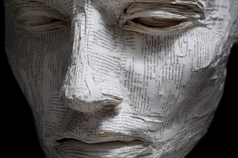 This shows a mask made of paper covered in words.
