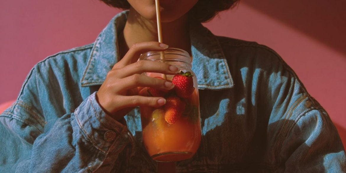 This shows a woman drinking a fruit juice.