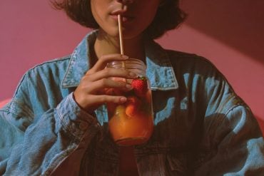 This shows a woman drinking a fruit juice.